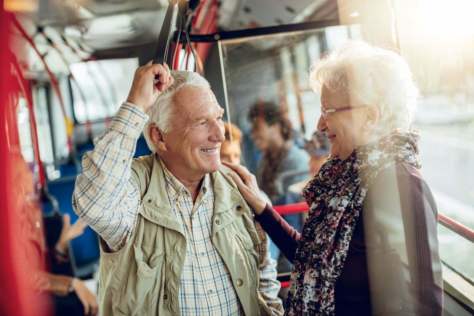 Elderly couple taking a bus ride for a day trip near their senior living community