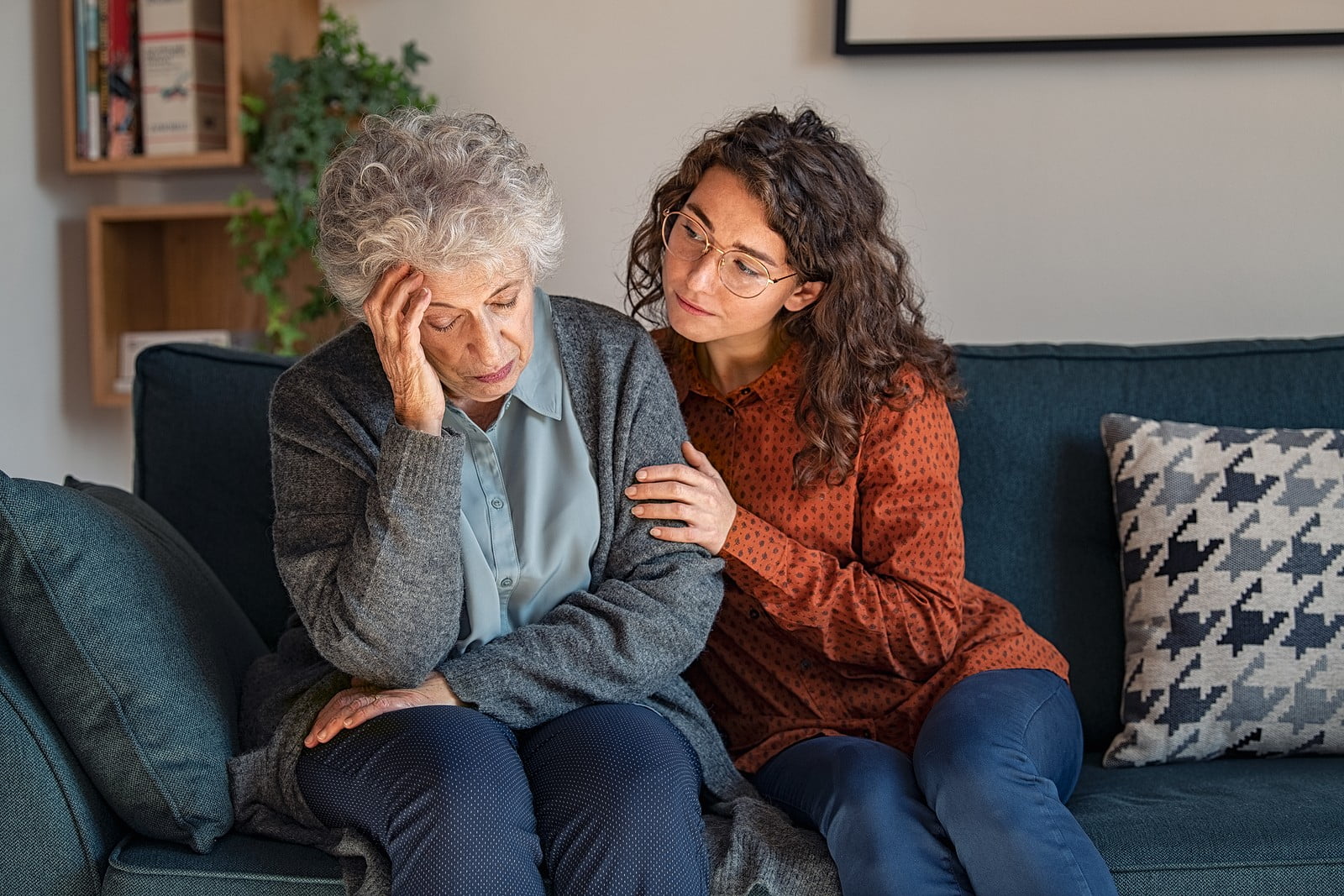 Woman supporting stressed senior.