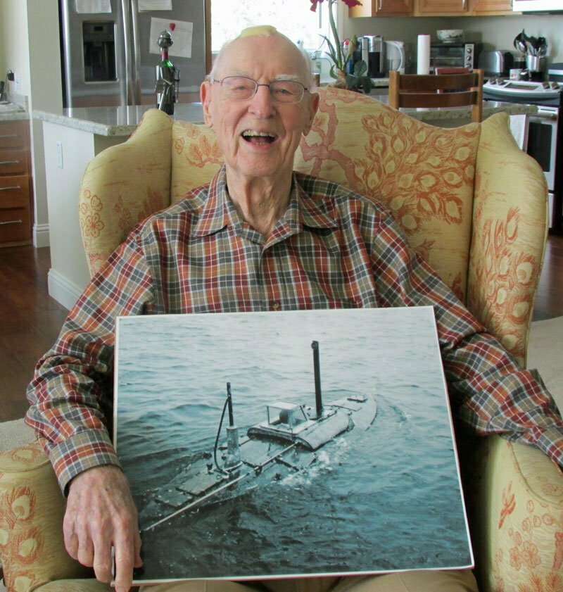 George McCullough, a Buckingham resident and veteran, holding a photo of the Navy ship he served on
