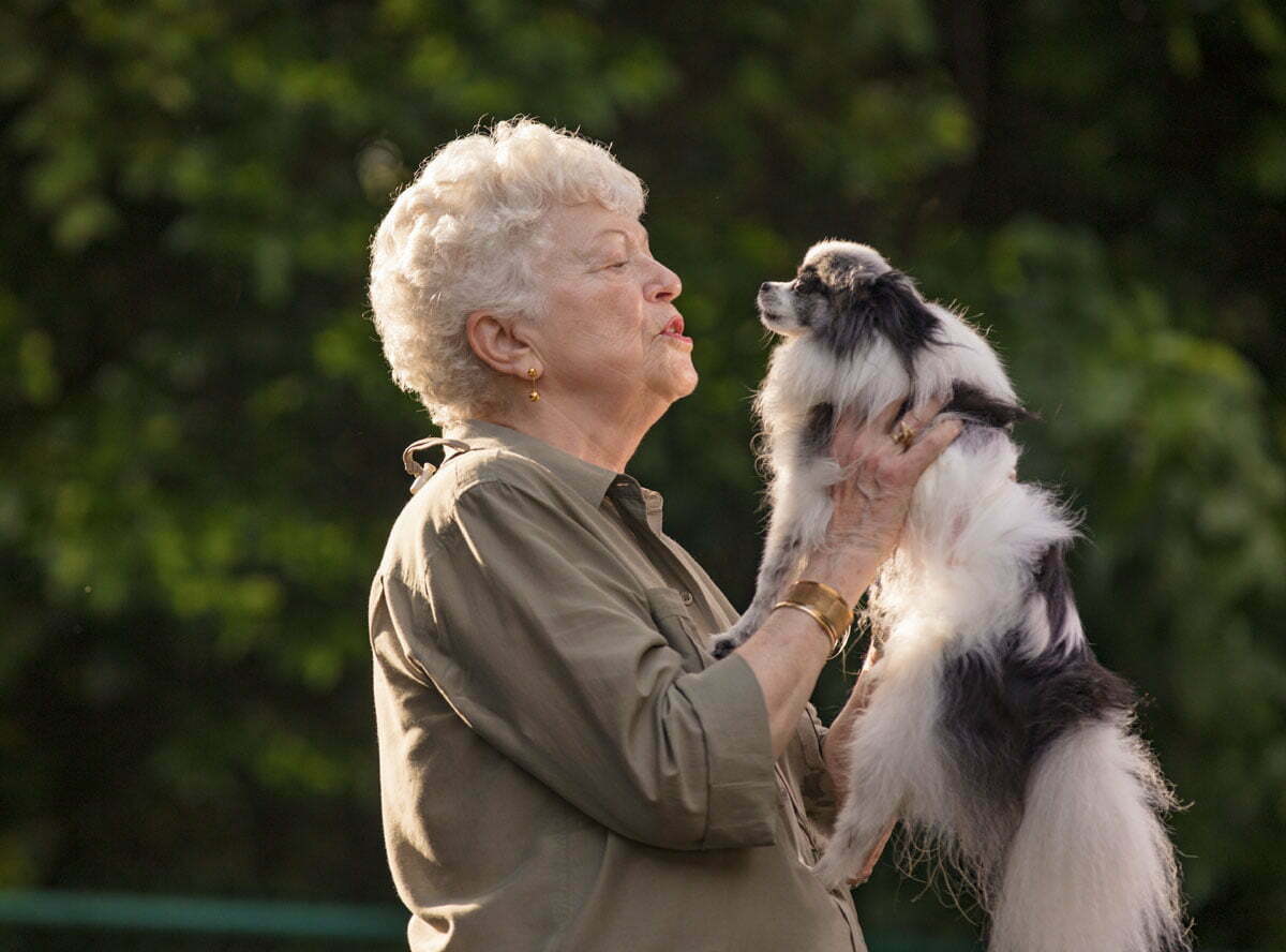 Senior woman enjoys pet friendly senior living with her dog.