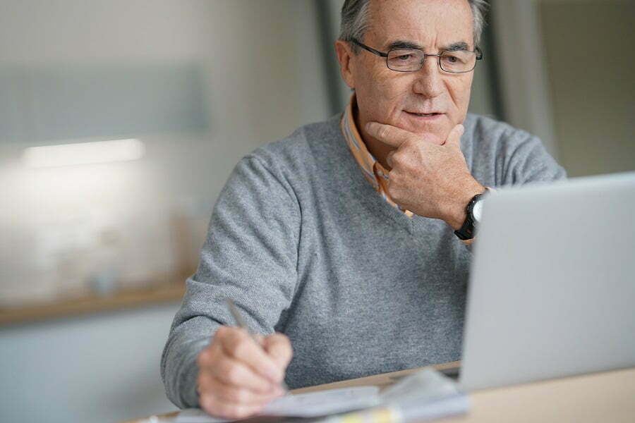senior man looking on a laptop how to virtually touring senior living communities