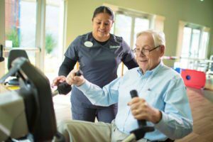 Therapist helping a senior man with rehabilitation exercises 
