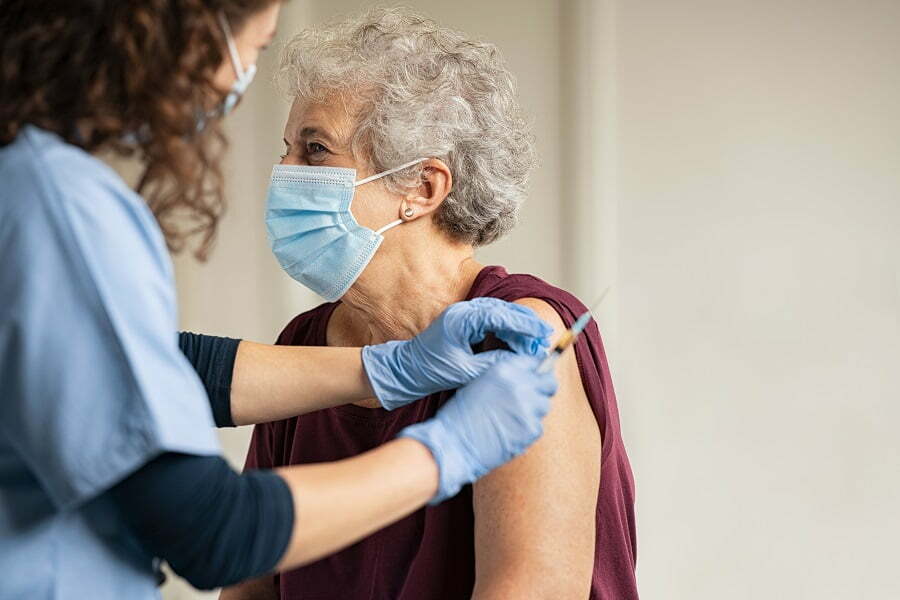 Senior receiving a vaccine from a healthcare worker