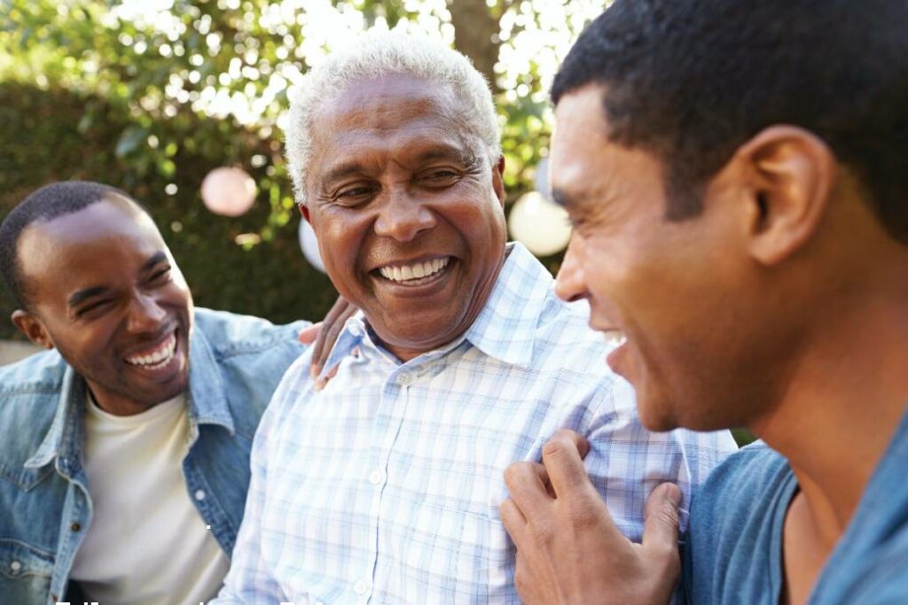 senior and two adult men laughing together outside
