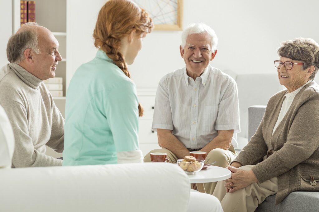 Seniors speaking with senior living facility caregiver.