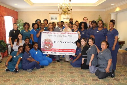 The Buckingham's staff posed around a sign stating that they received National Quality Award for 2017