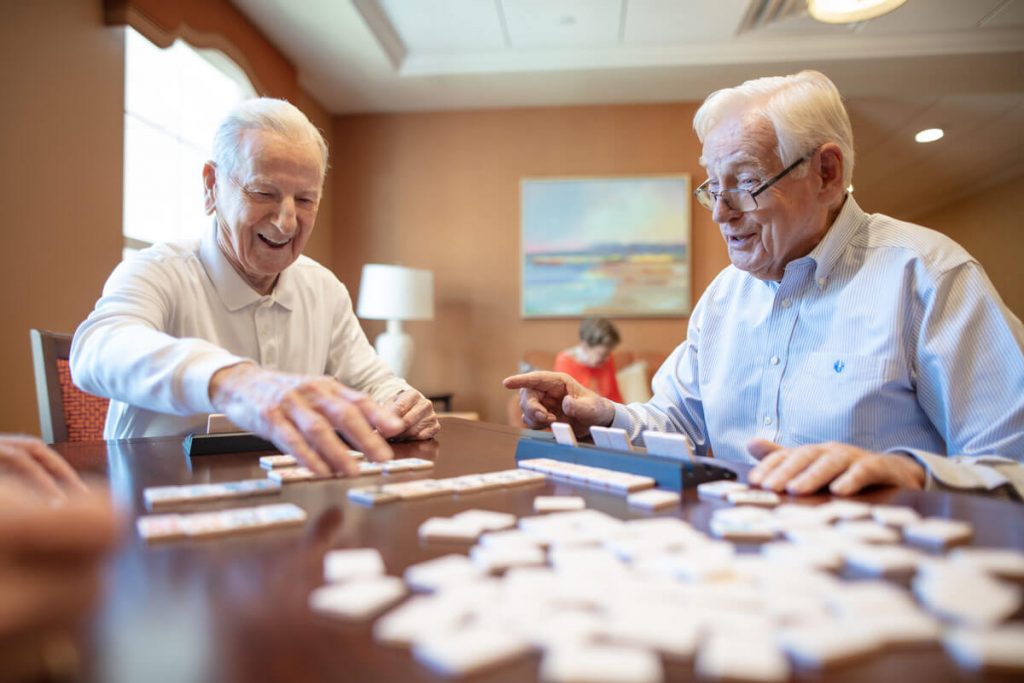 Assisted living residents enjoying a game of dominos